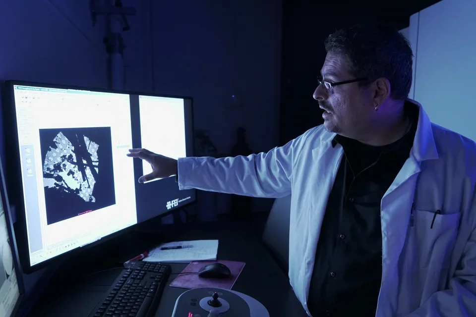 Gonen pointing at computer in lab